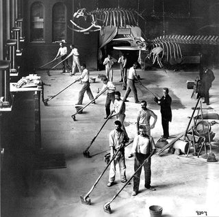 Workers grinding and polishing a terrazzo floor in a large public building, circa mid-20th century